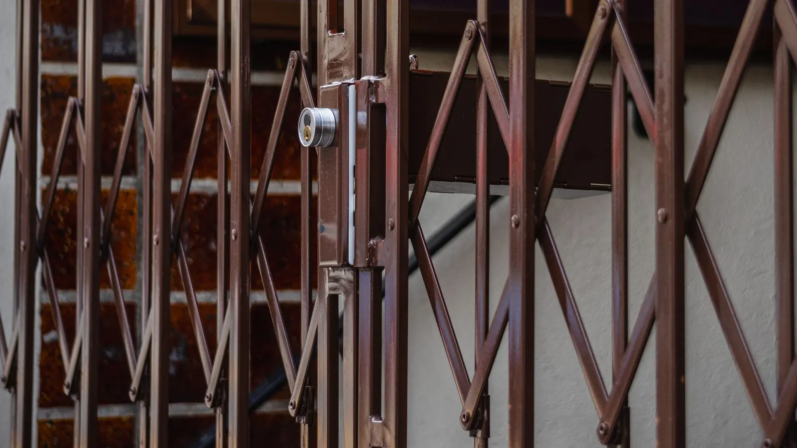 Brown folding metal security door with a lock