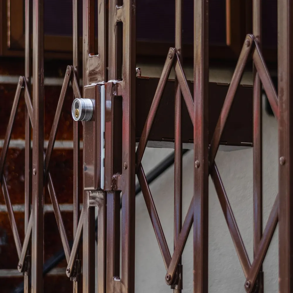 Close view of the scissor lattice and lock of a folding metal door