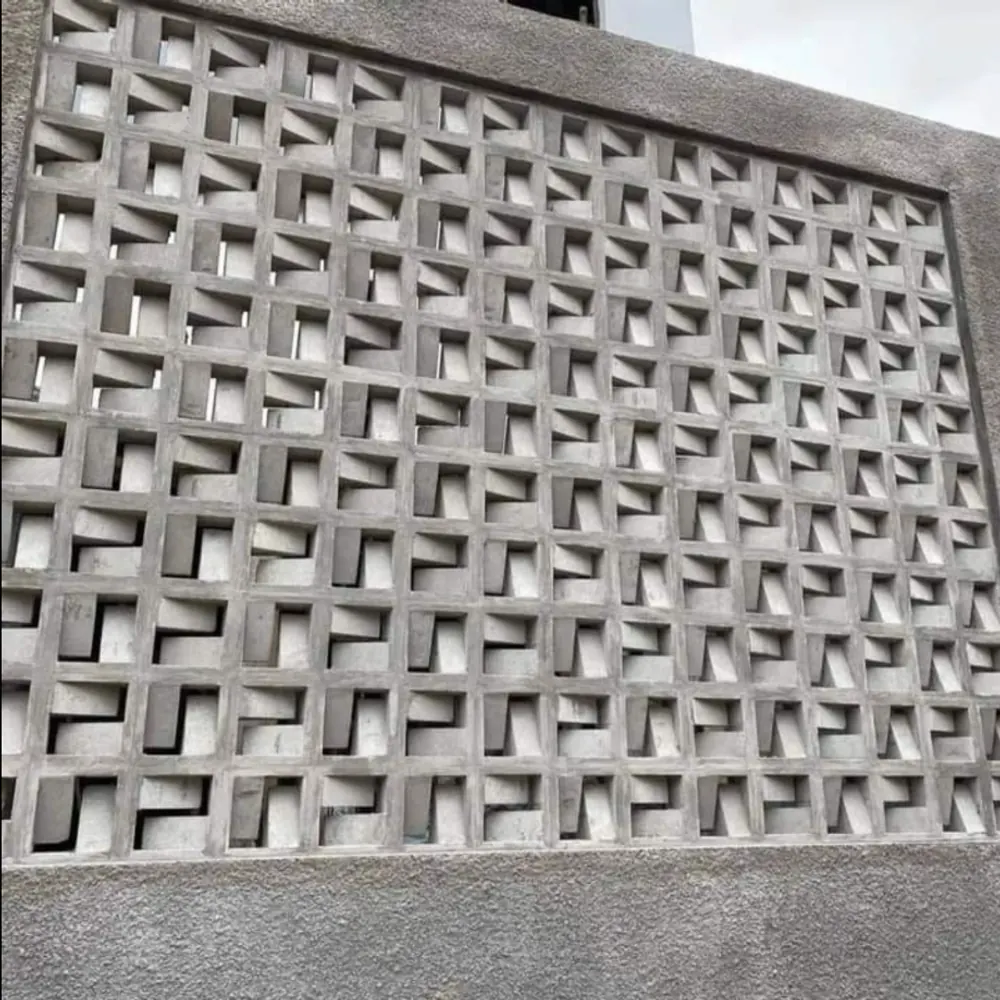 Wall of patterned concrete breeze blocks set in a rendered frame